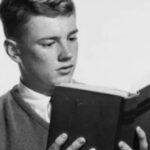 retro style young man reading hardcover book